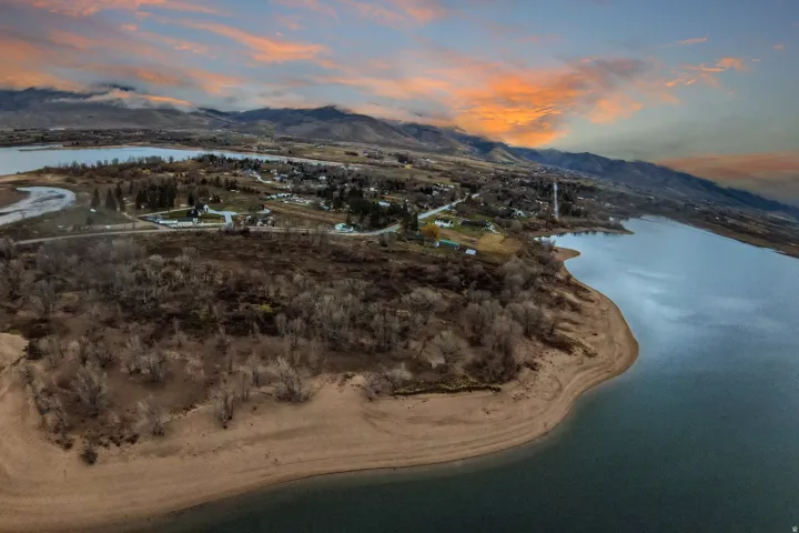 Expansive waterfront property featuring a sandy shoreline and direct access to the lake