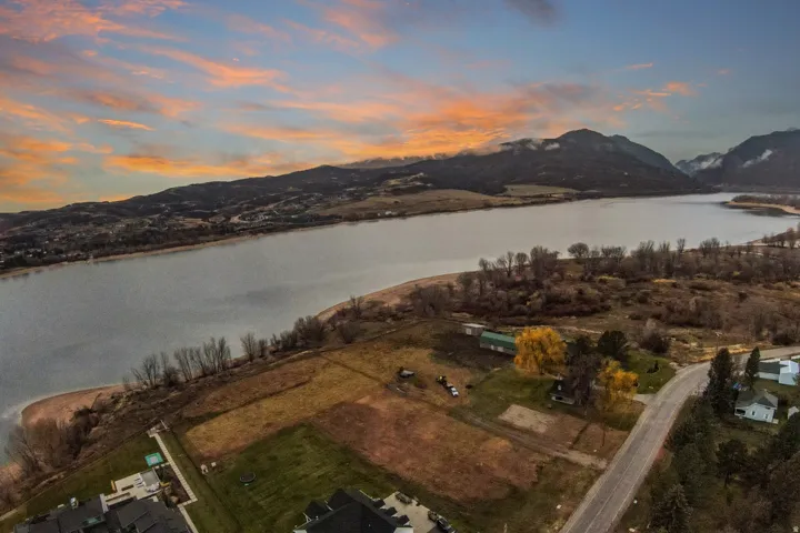 Expansive waterfront property featuring a substantial land parcel, direct water access, and mature trees