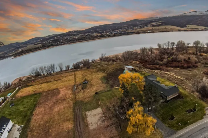 Expansive property featuring a waterfront location, a spacious residence, an additional auxiliary structure, and a paved driveway