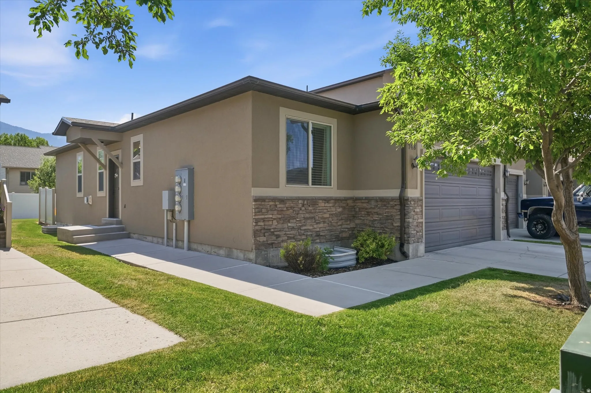 Exterior facade featuring stucco siding with a stone veneer accent