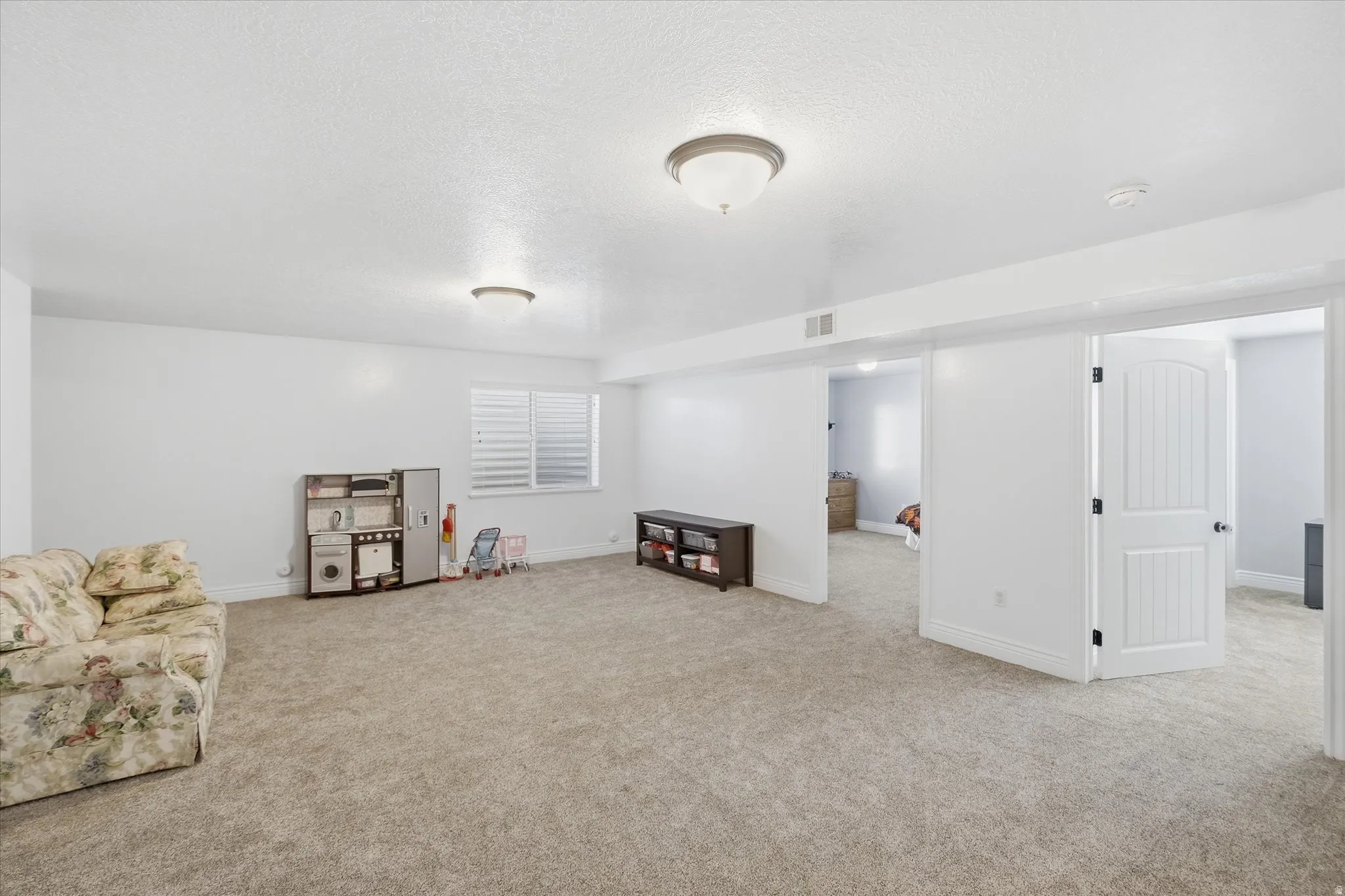 Carpeted interior space featuring white walls and recessed lighting