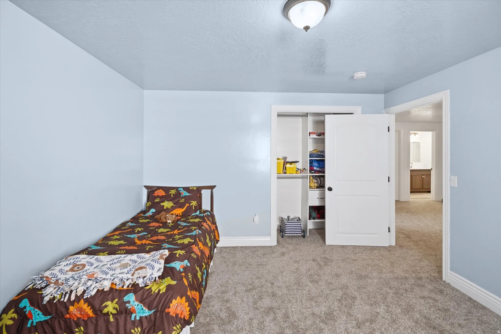 Carpeted interior room featuring light blue walls and white trim