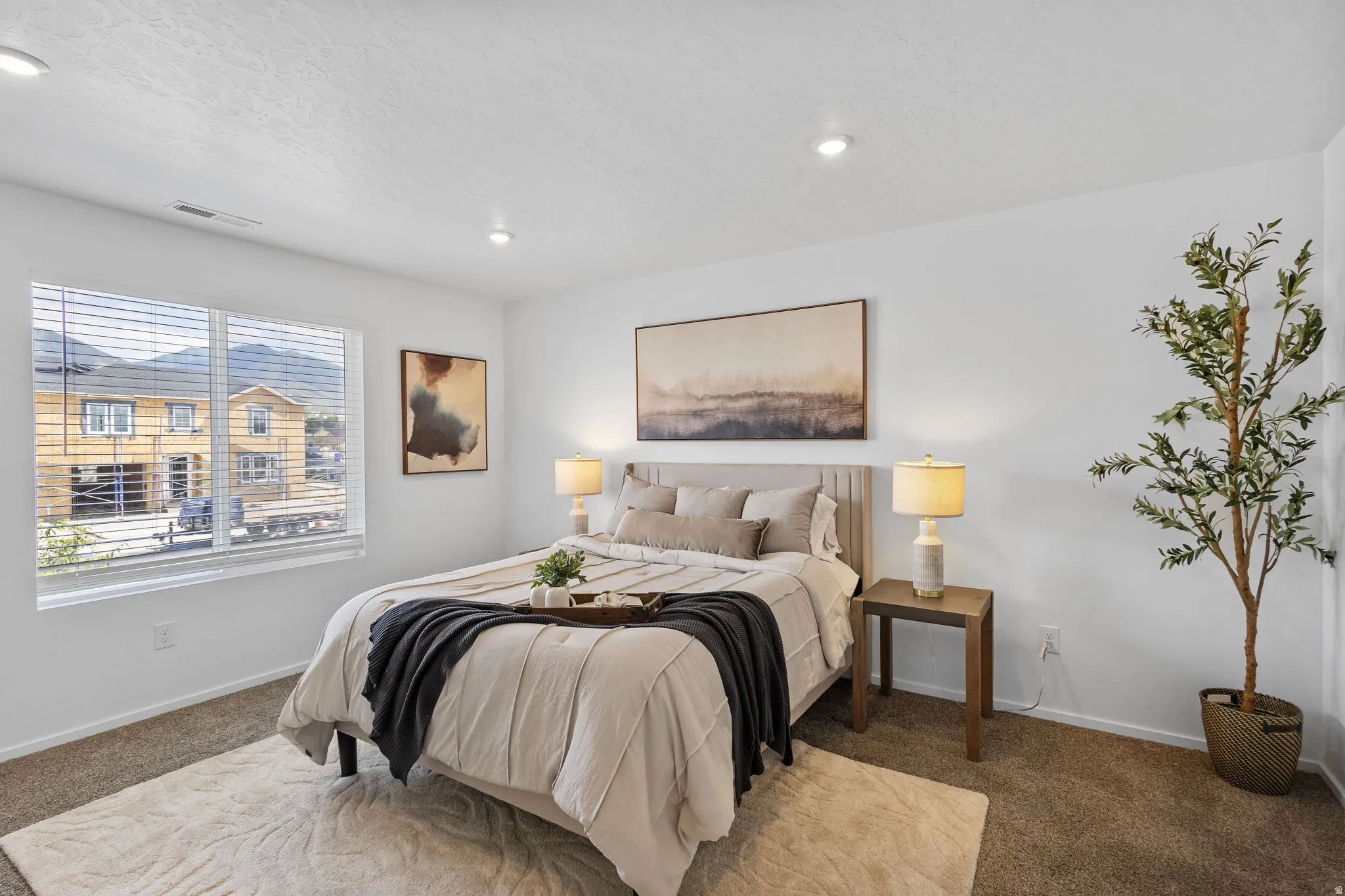 Carpeted bedroom featuring recessed lighting, a large window with mountain views, and a neutral color palette