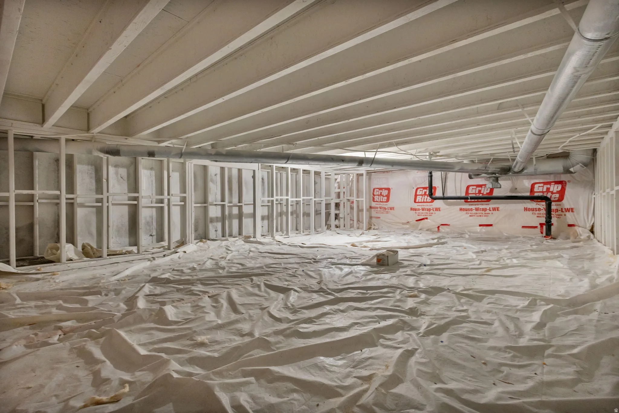A fully encapsulated crawl space featuring a vapor barrier floor, pre-framed perimeter walls, exposed mechanicals, and a post-build ventilation system