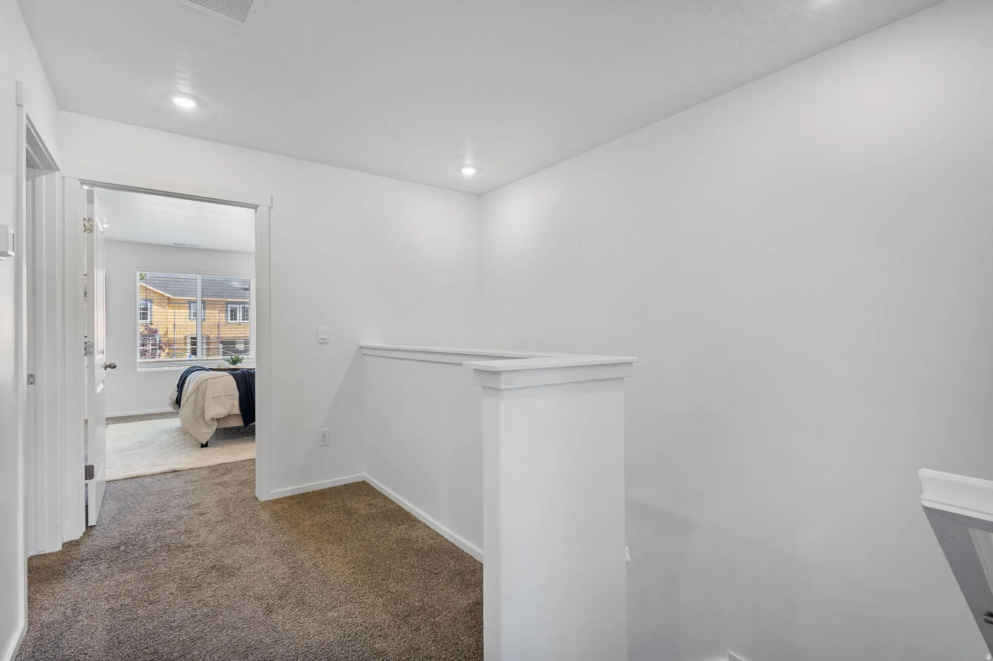 Interior hallway featuring neutral carpeting and white wall finishes