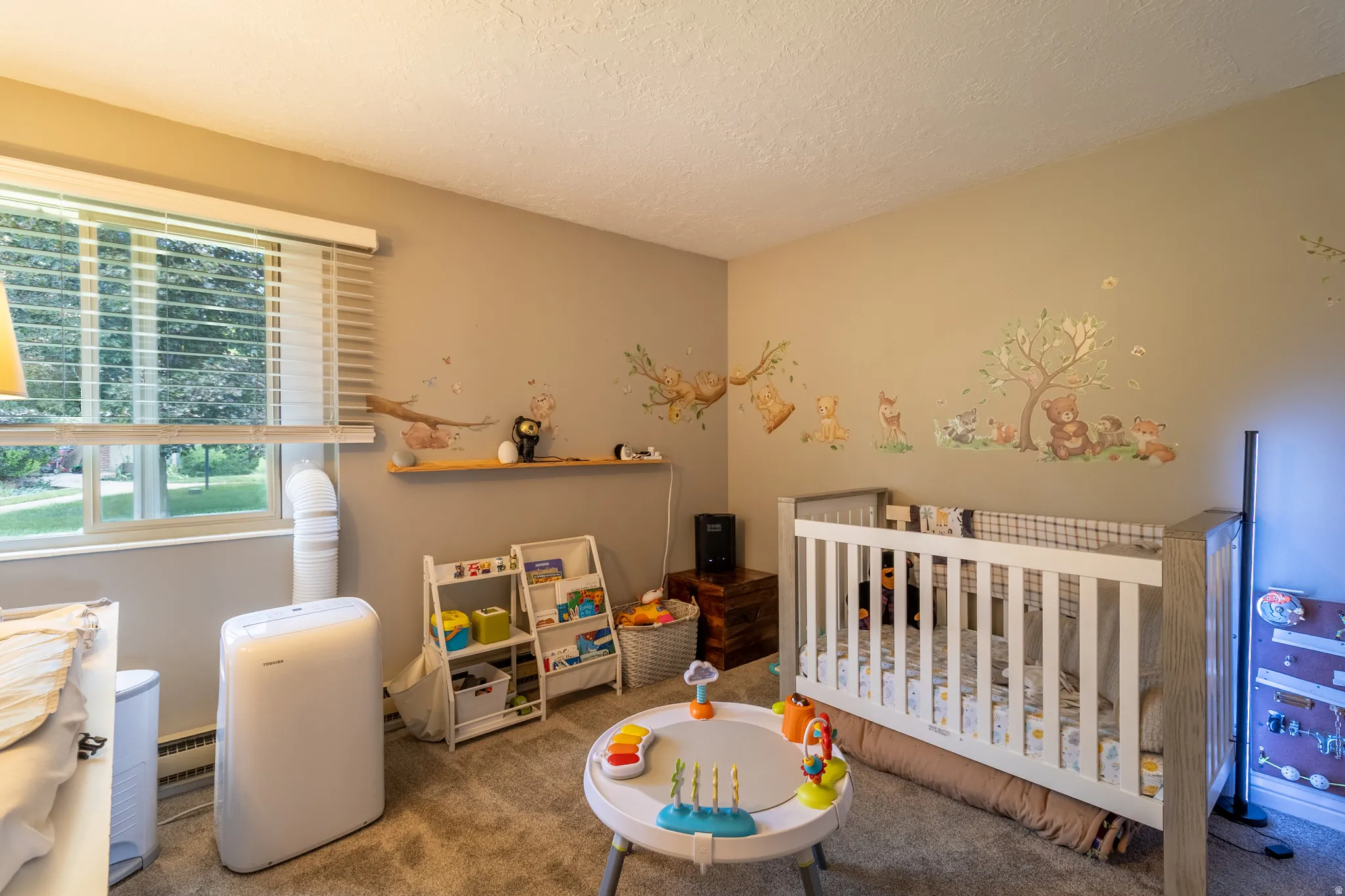 Carpeted room with neutral wall tones and a single window featuring horizontal blinds