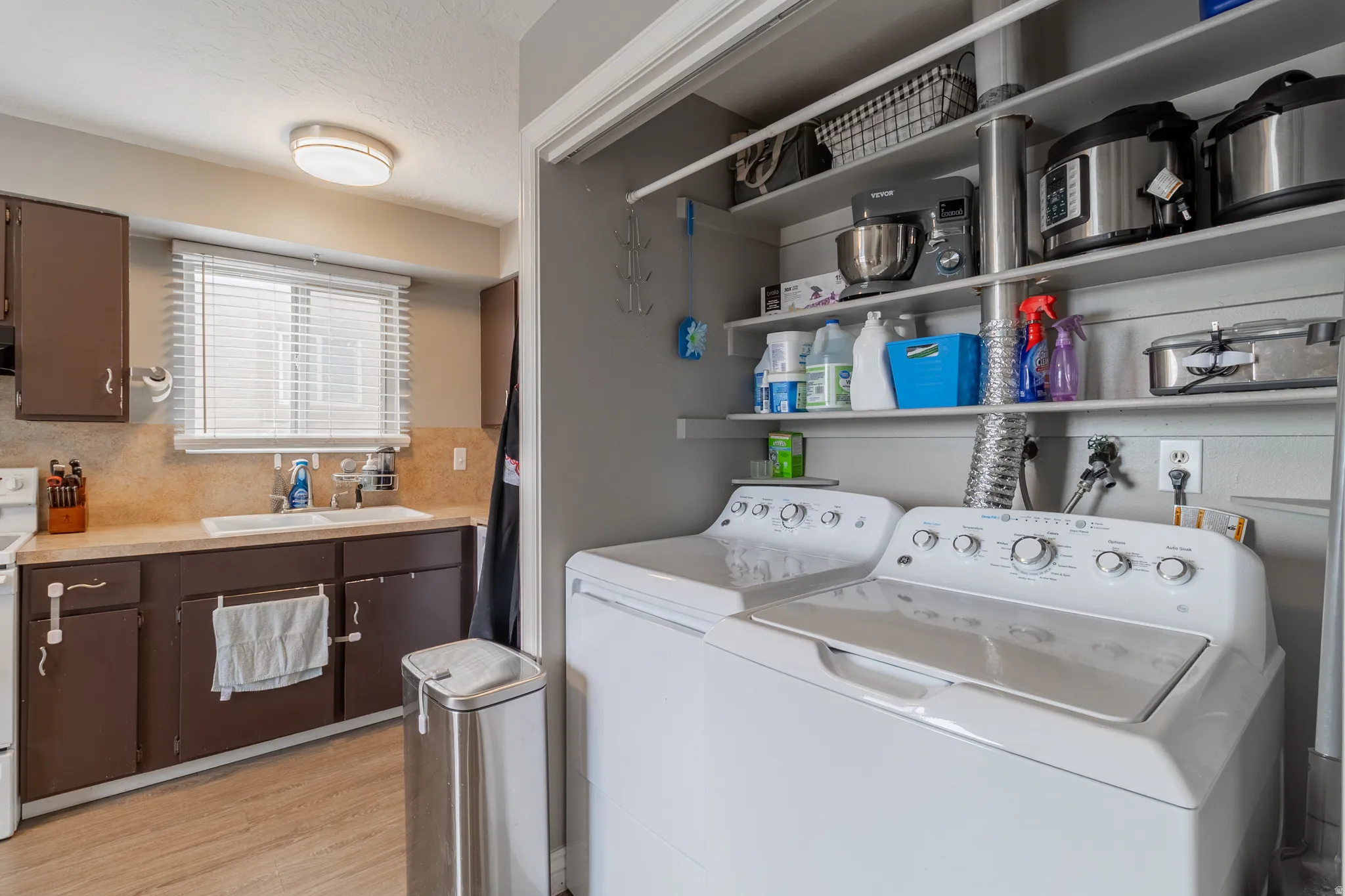 Dedicated laundry area featuring white appliances and built-in shelving