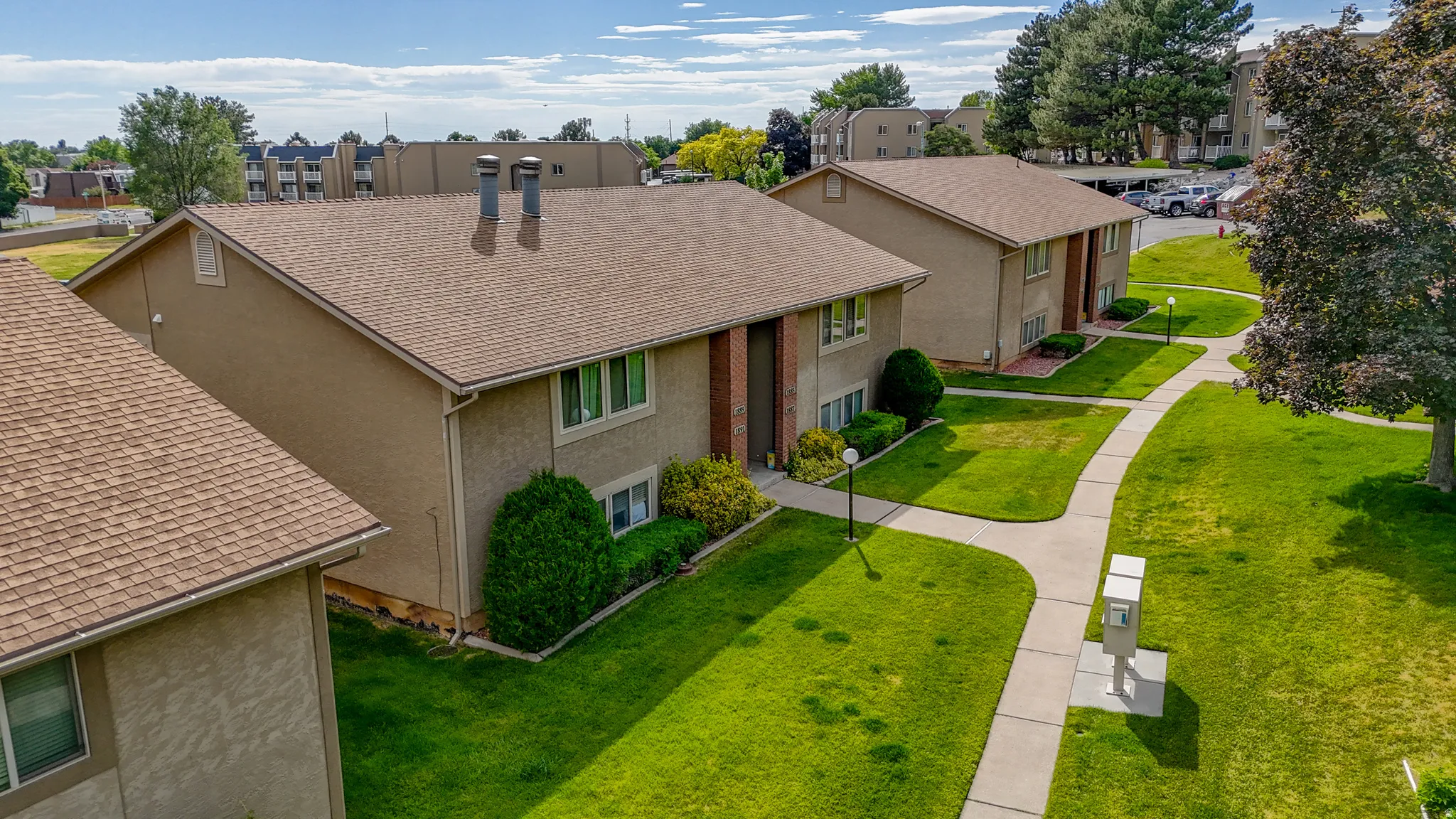 Well-maintained grounds featuring expansive lawns, mature trees, and paved walkways