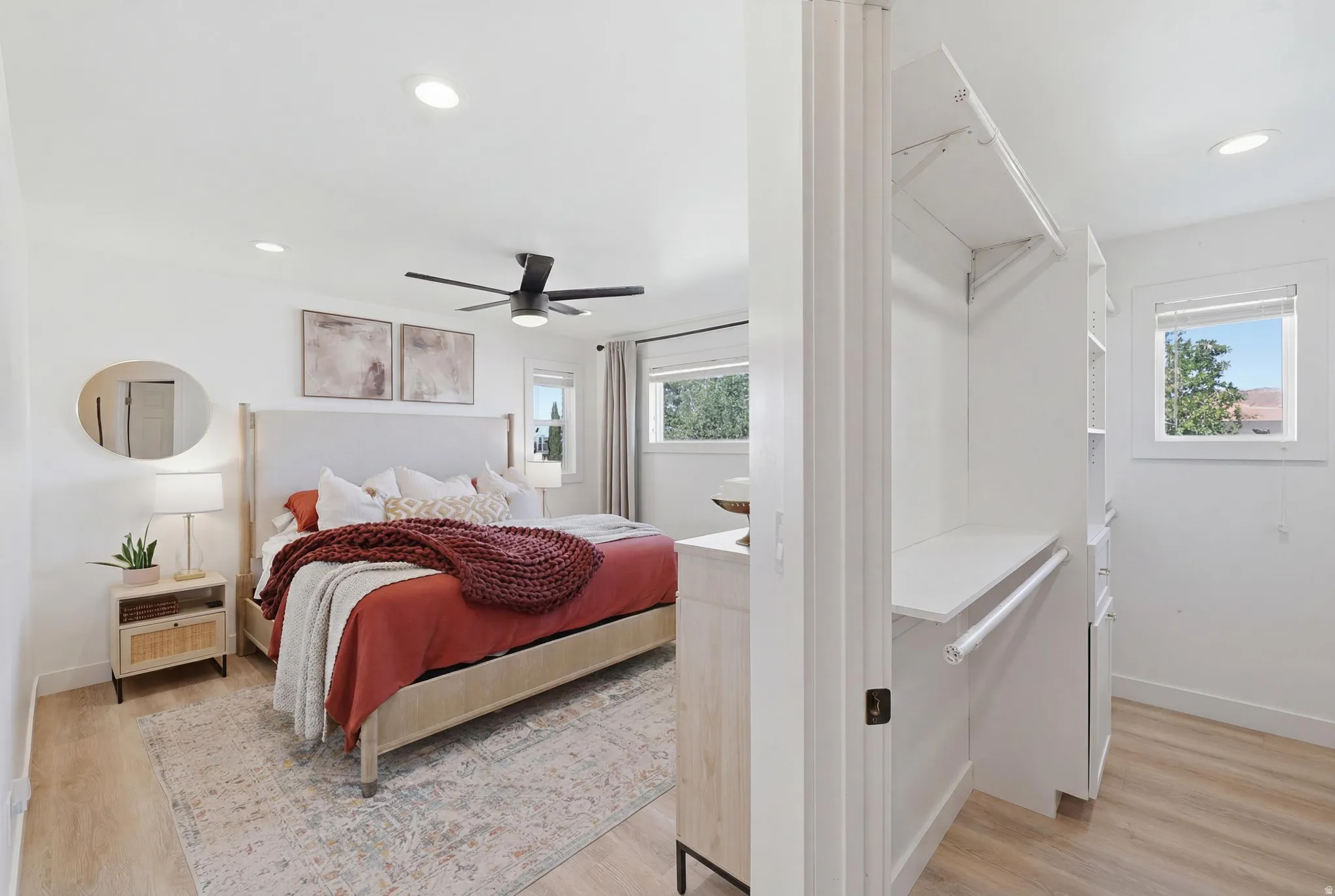 Bright bedroom featuring wood-finish flooring and recessed lighting