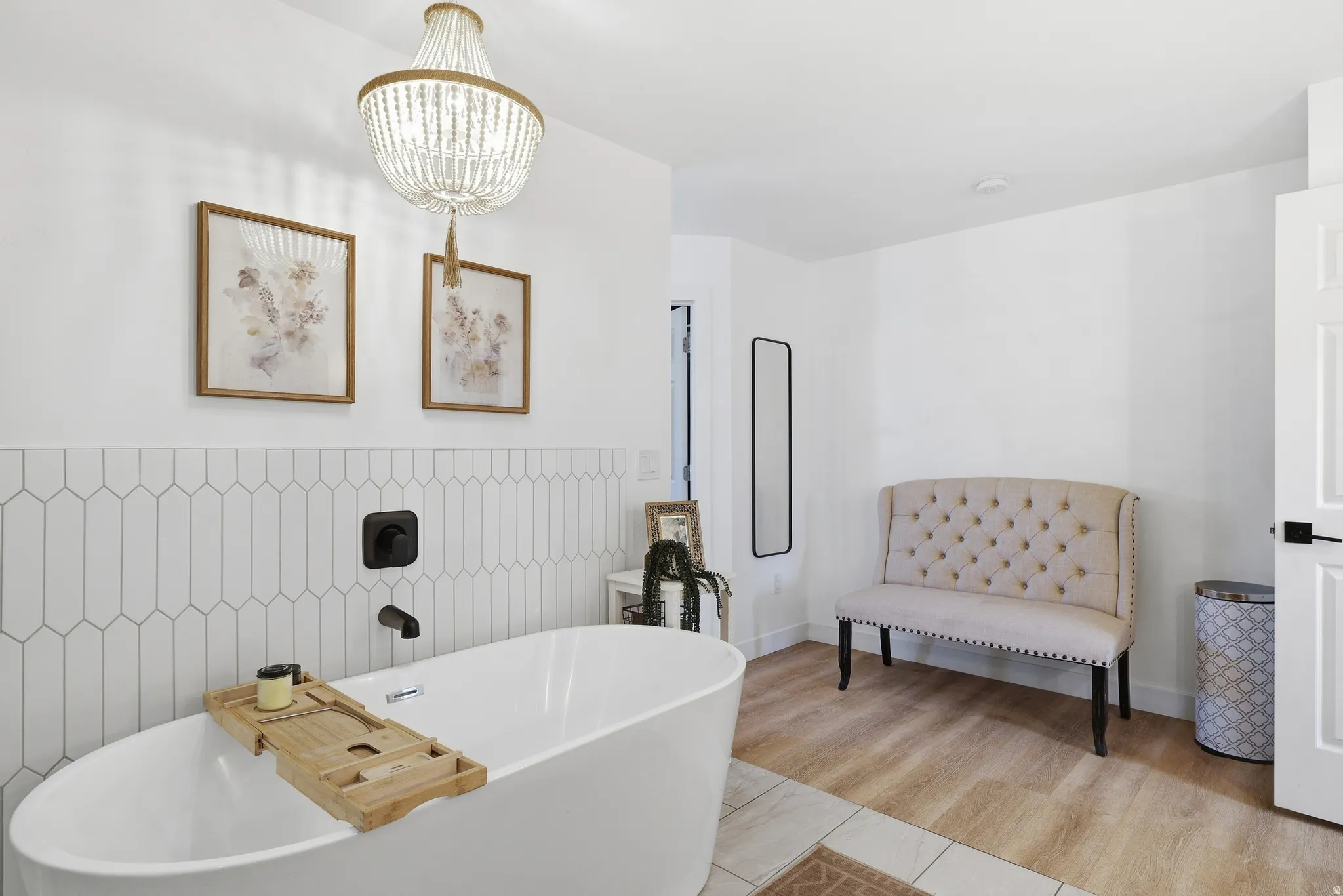 Freestanding soaking tub with matte black fixtures, set against a picket-patterned tile accent wall