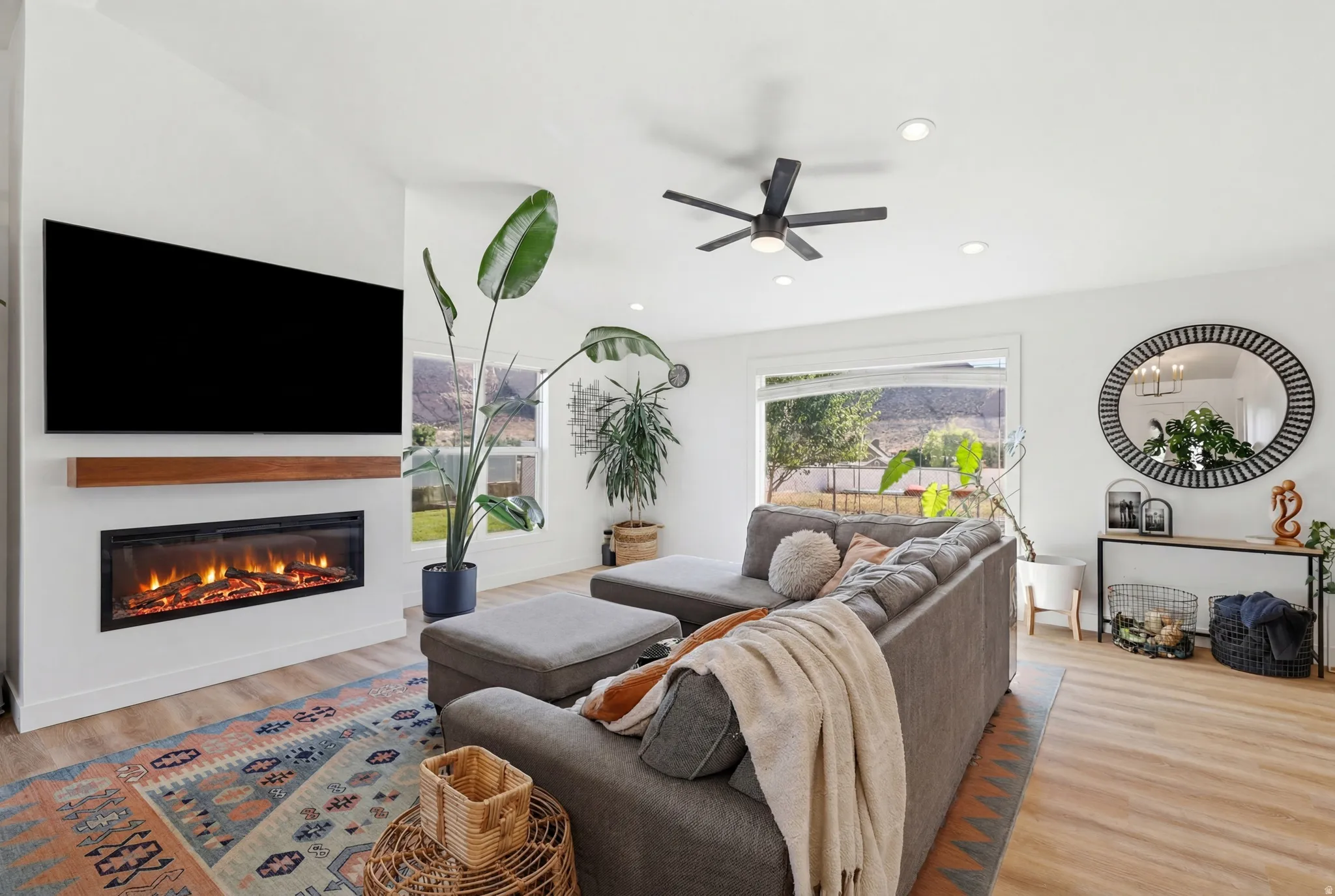 Living area featuring a built-in electric fireplace with a wood-finish mantel, wood-finish flooring, recessed lighting, and a ceiling fan