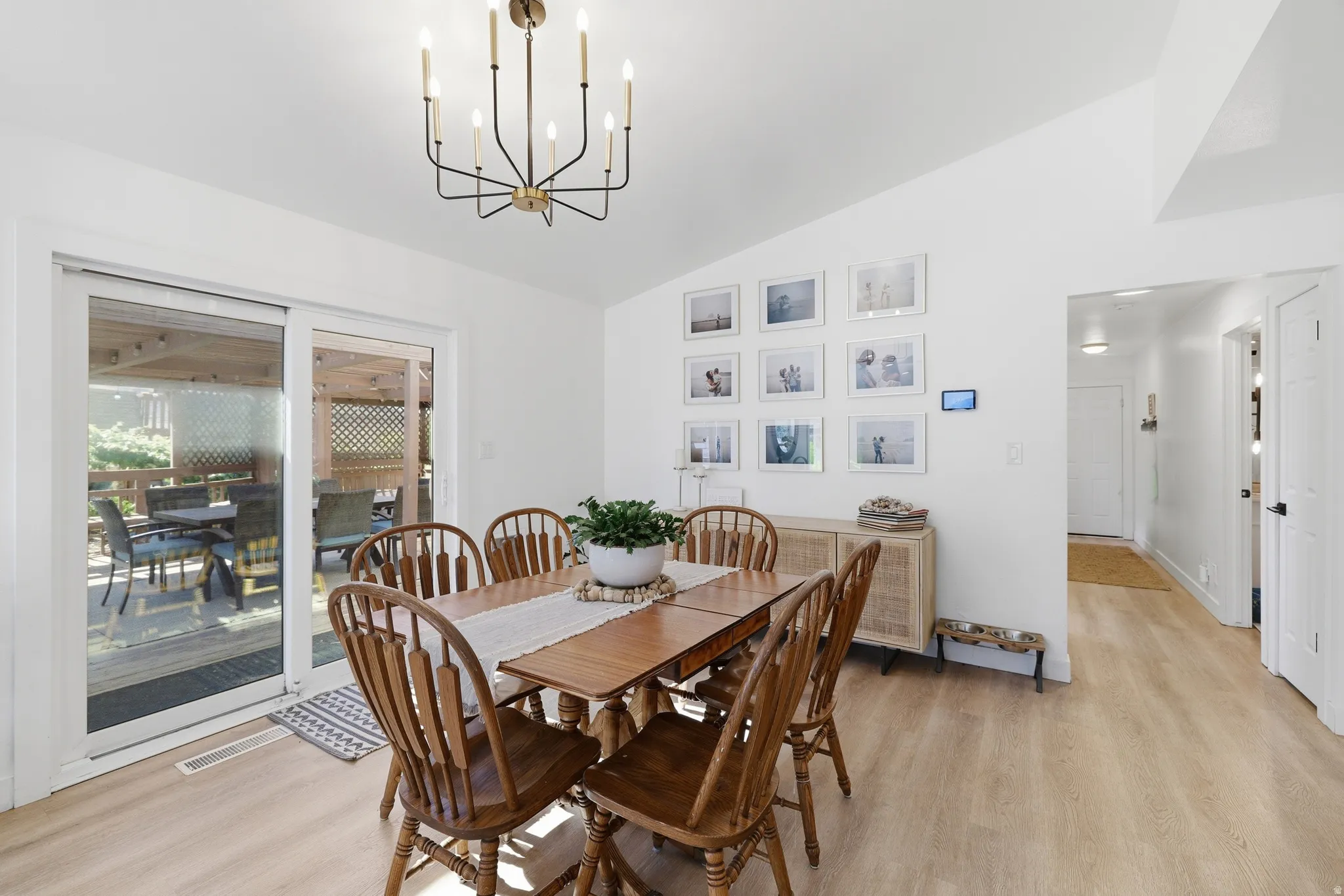 Dining area featuring wood-finish flooring and a contemporary chandelier