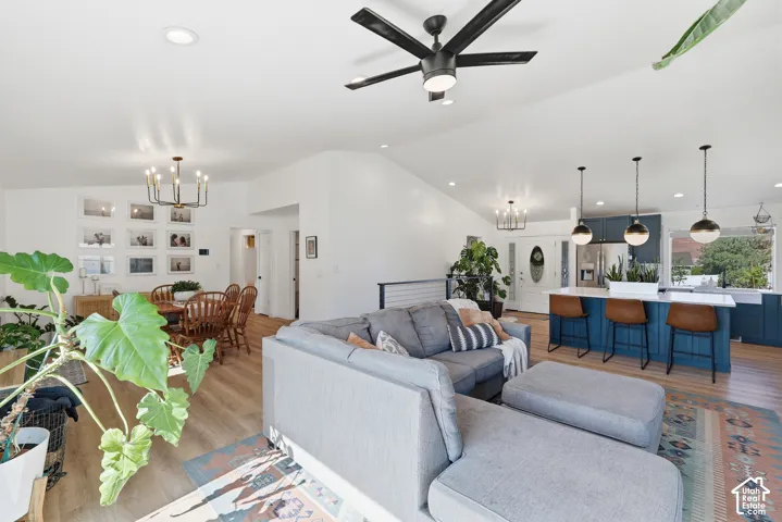 Vaulted ceilings and recessed lighting illuminate an open-concept living space featuring wood-finish flooring throughout