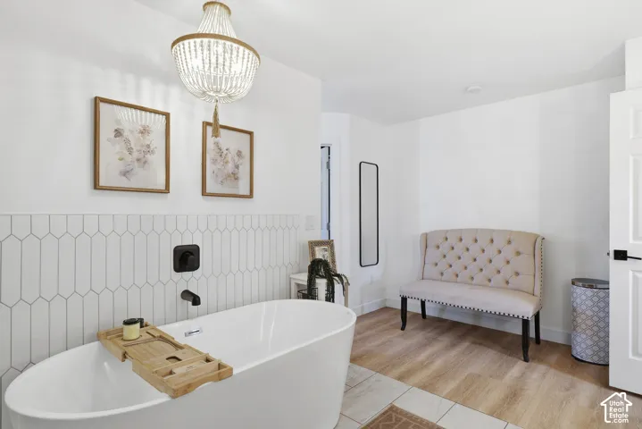 Freestanding soaking tub with matte black fixtures, set against a picket-patterned tile accent wall