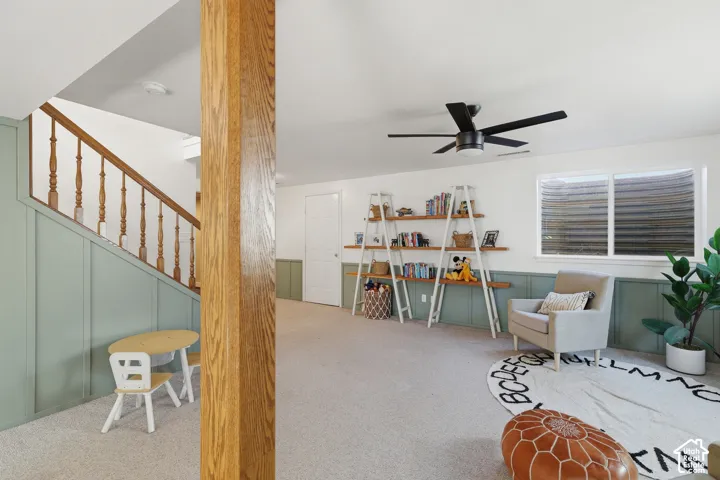 Finished lower level featuring light green wainscoting, white walls, and light-colored carpeting