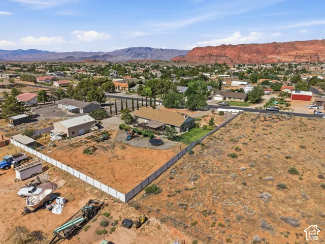 Expansive property featuring a large land parcel, a single-story residence, and a substantial detached garage/workshop