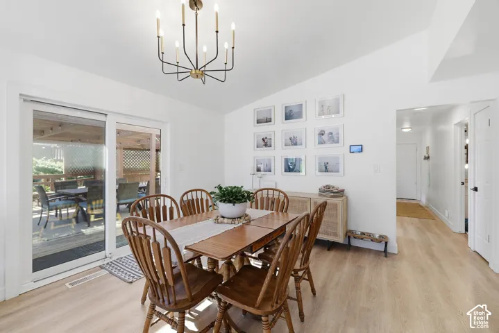 Dining area featuring wood-finish flooring and a contemporary chandelier