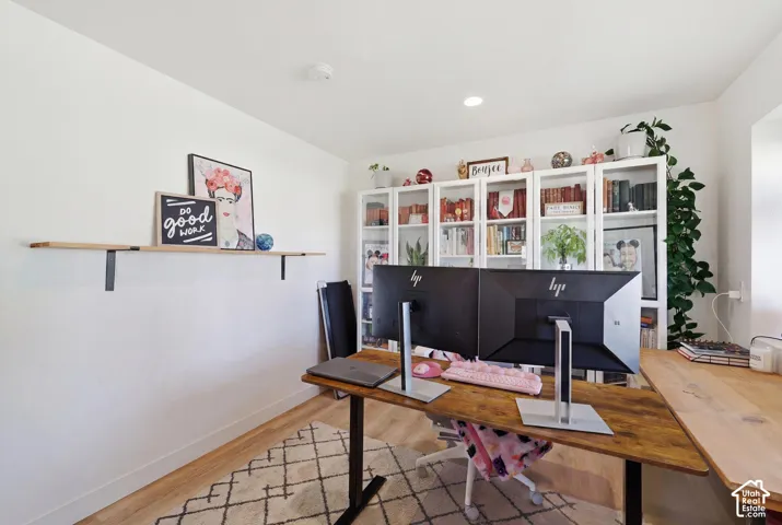 Dedicated office space featuring wood-finish flooring and white painted walls