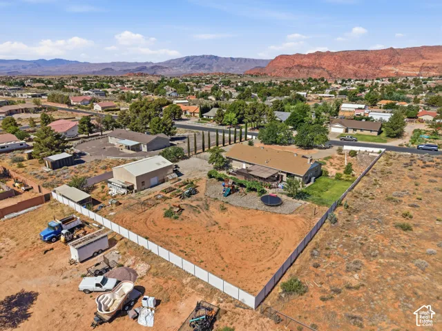 Expansive property featuring a main residence, a detached auxiliary building, and a private perimeter fence