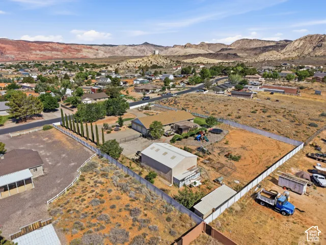 Expansive property with a residential structure featuring a shingle roof and a separate metal-clad outbuilding