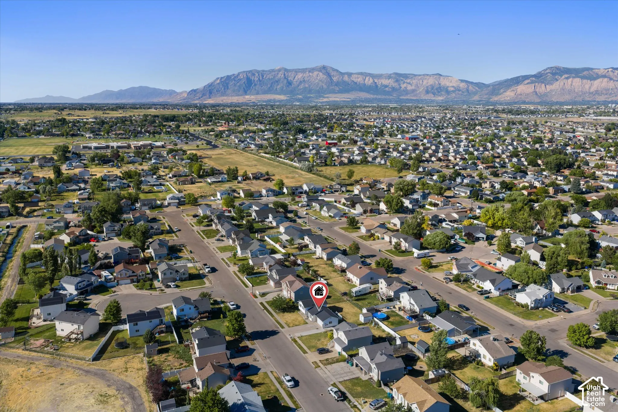 Residential neighborhood featuring a street grid, mature landscaping, and mountain backdrop