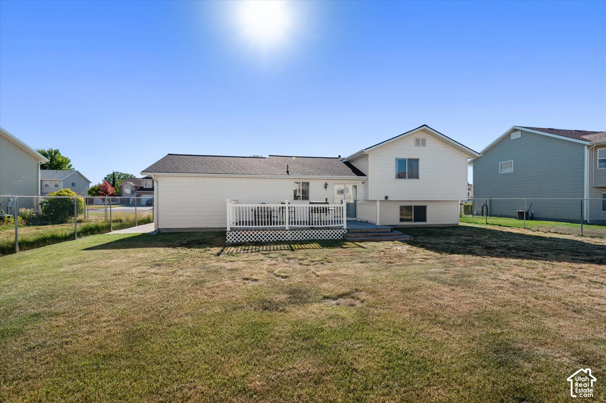 Rear exterior with white siding and a multi-level deck featuring white railings