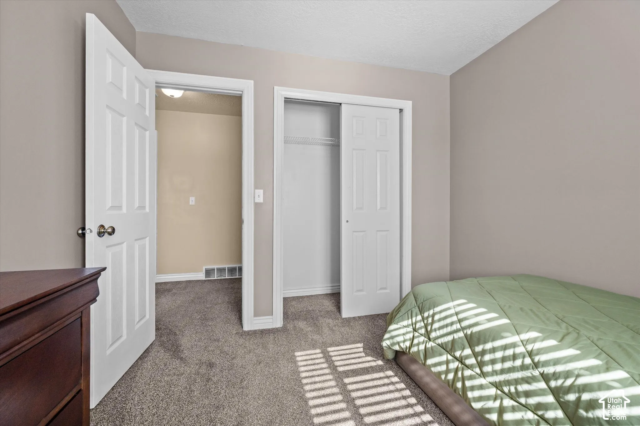 Carpeted room with neutral wall tones and a white six-panel door