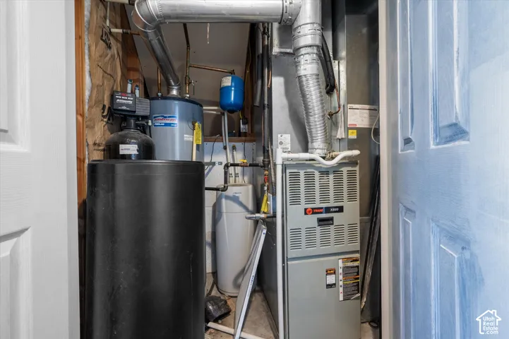 Mechanical closet featuring a water heater, furnace, and water conditioning system