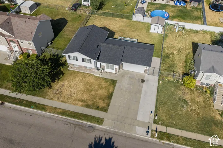 Single-story residence featuring a dark shingle roof, light-colored siding, and a stone-clad foundation