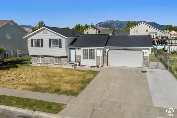Split-level residence featuring a two-car garage with an extended concrete driveway
