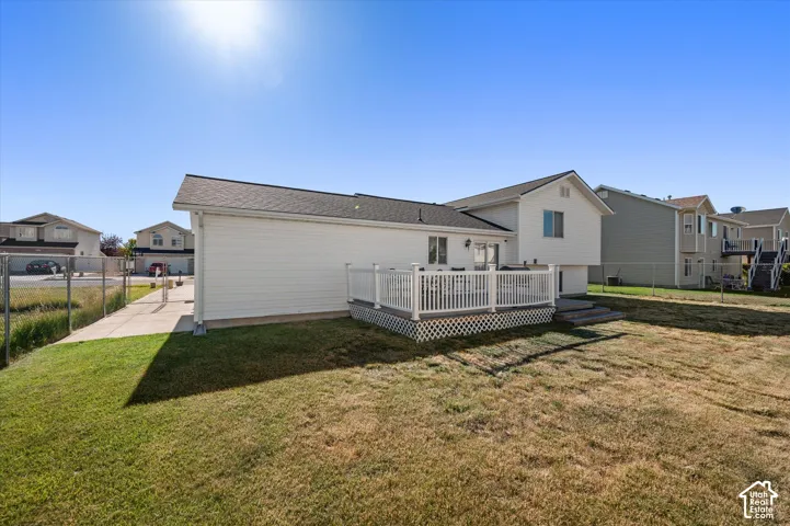 Expansive backyard featuring a white vinyl deck with lattice skirting and a privacy railing