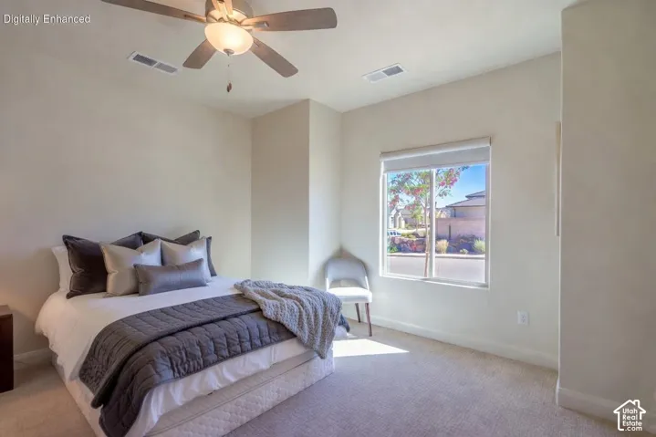 Spacious bedroom featuring light-colored carpeting, a window with a roller shade, and a ceiling fan with integrated lighting Virtually Enhanced
