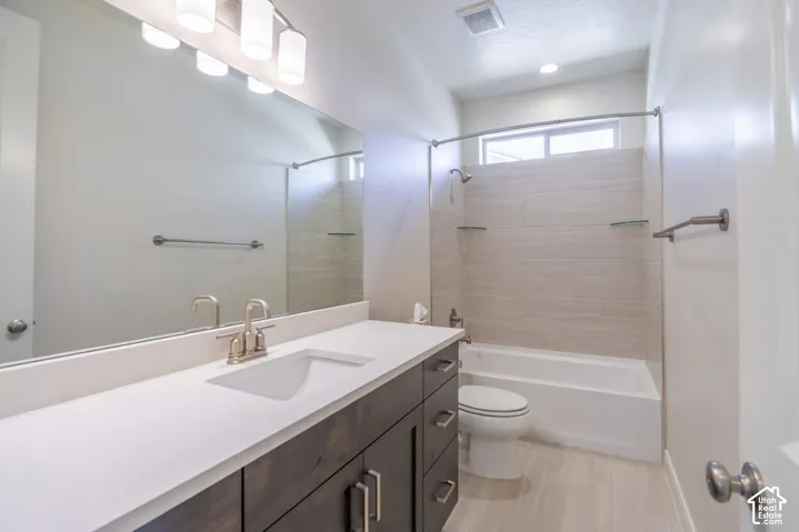 Spacious bathroom featuring a dark wood-finish vanity with a white countertop and undermount sink