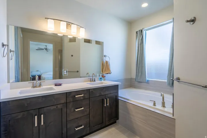 Dual sink vanity with dark wood-finish cabinetry and light-toned countertops