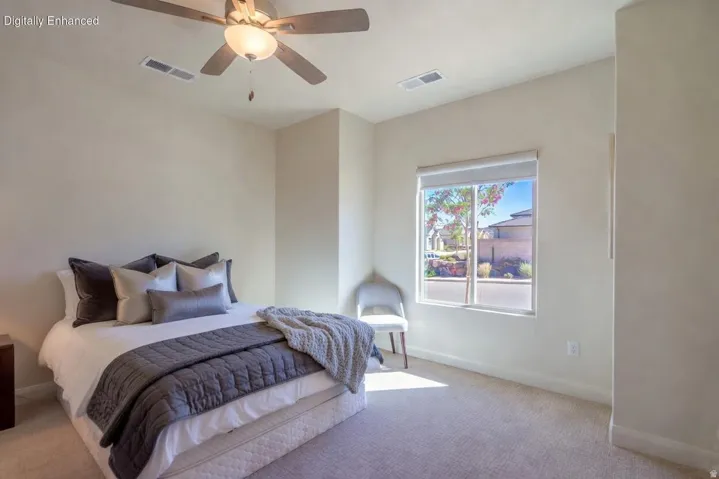 Spacious bedroom featuring light-colored carpeting, a window with a roller shade, and a ceiling fan with integrated lighting Virtually Enhanced