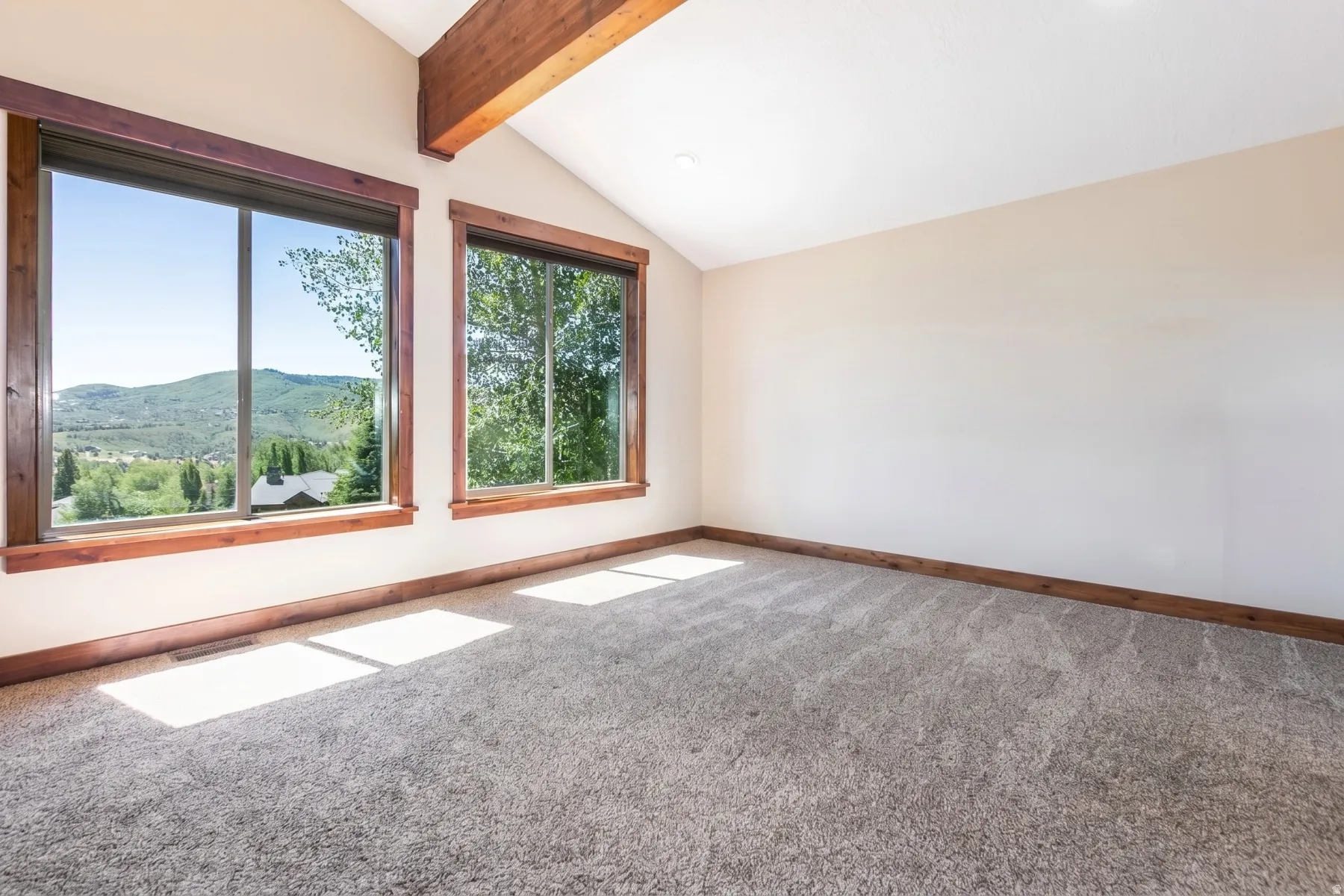 Vaulted ceiling with exposed wood beam and recessed lighting