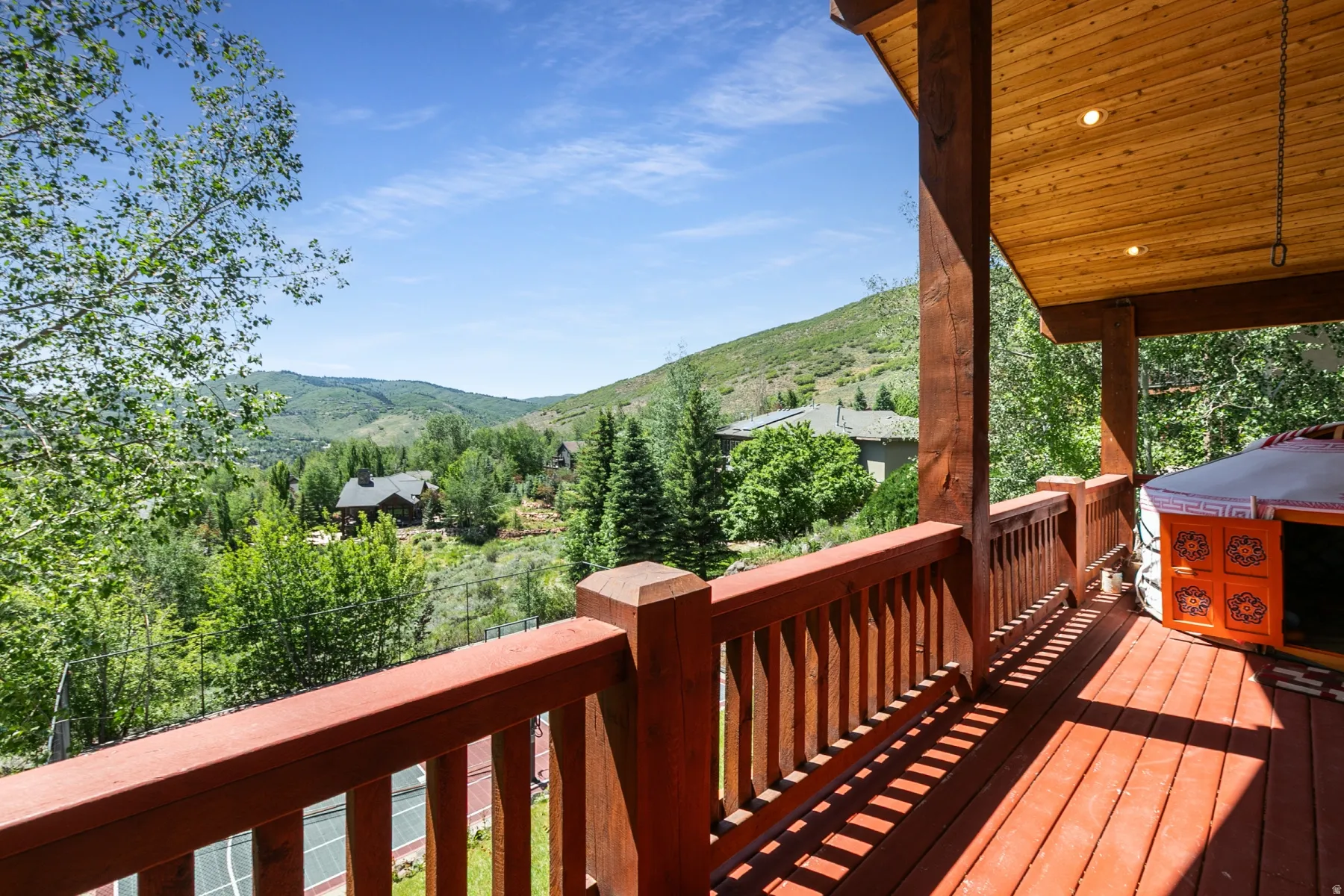 Spacious wood deck with a natural wood railing, wood-finish flooring, and a wood-paneled ceiling with recessed lighting