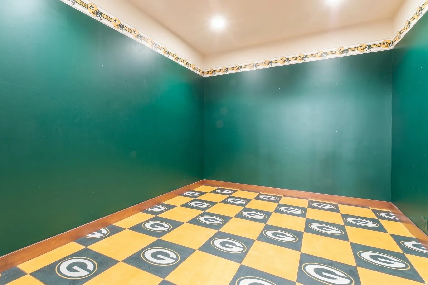 Room featuring dark green painted walls, a patterned floor, and recessed ceiling lighting