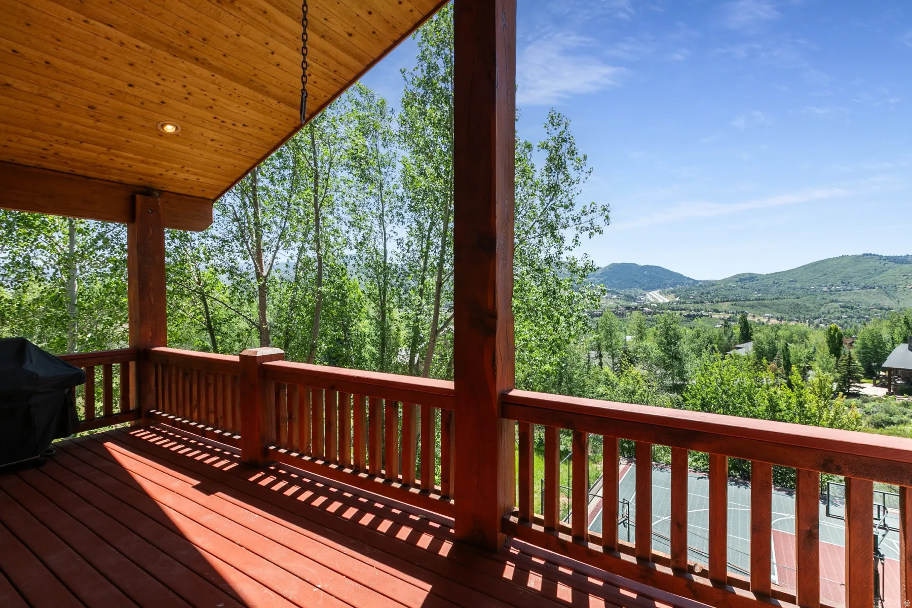 Expansive outdoor deck featuring wood-finish flooring and railing