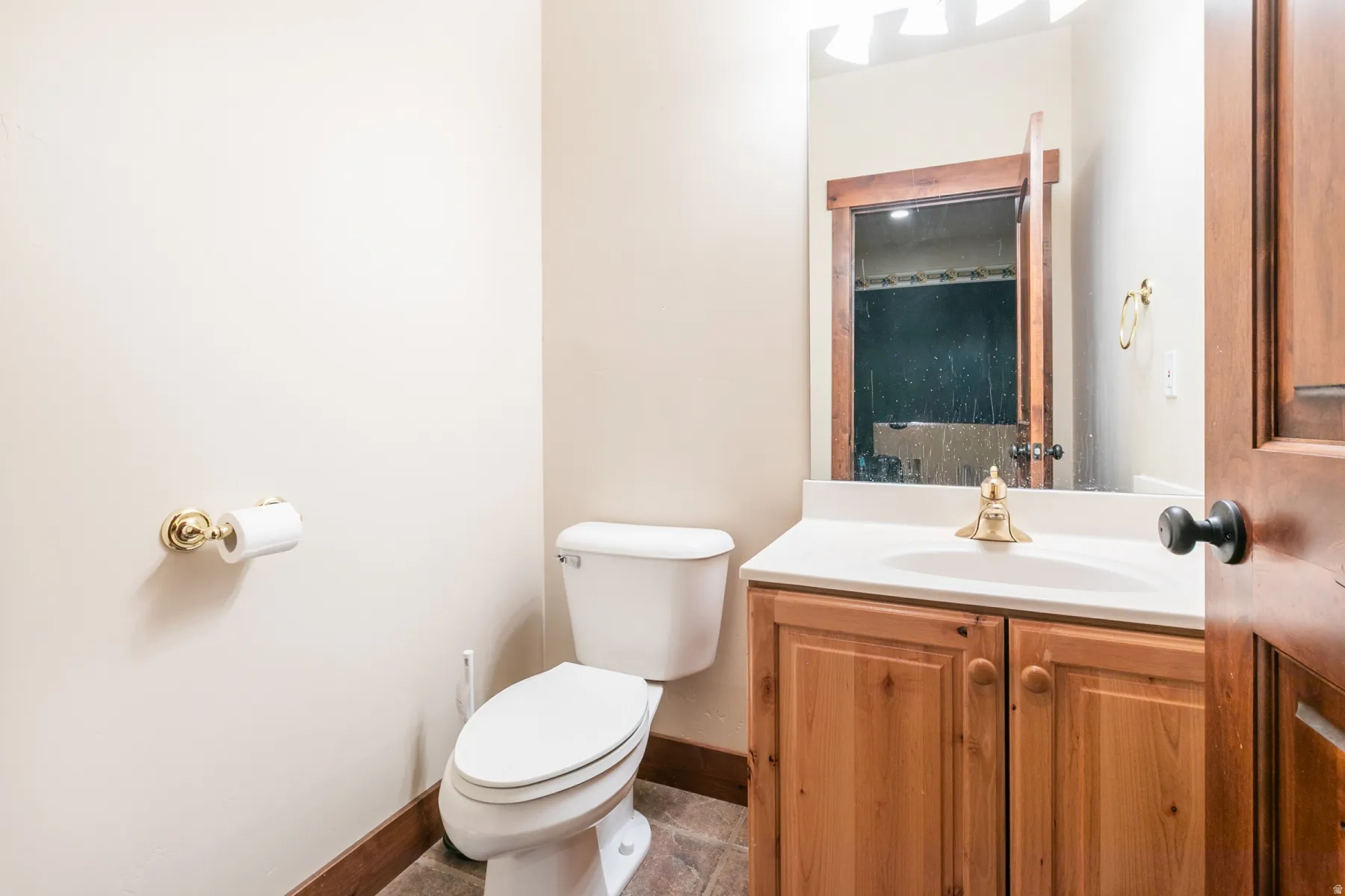 Bathroom featuring a wood-finish vanity with a white countertop and an undermount sink