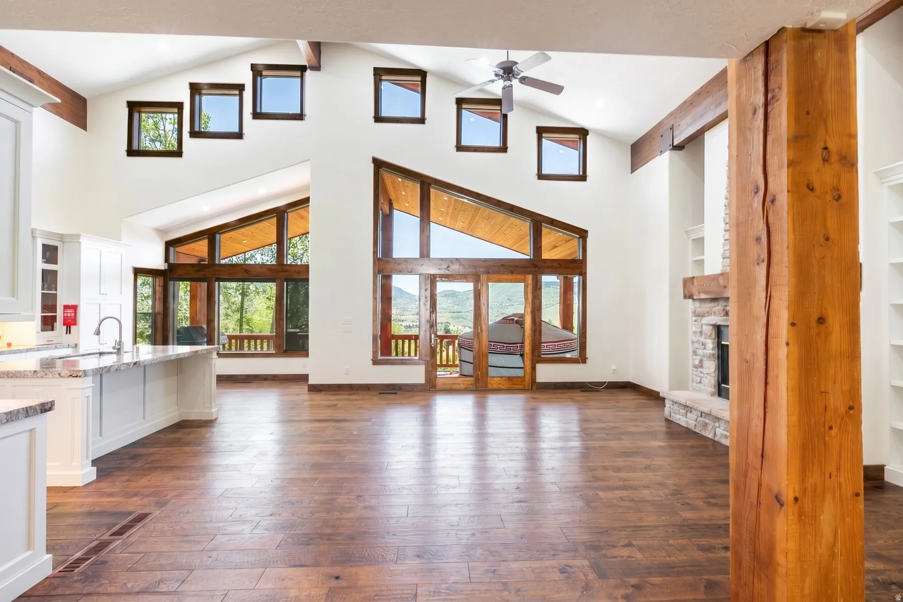 Vaulted ceilings featuring exposed timber beams and an array of windows
