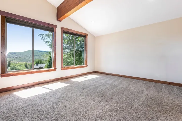 Vaulted ceiling with exposed wood beam and recessed lighting
