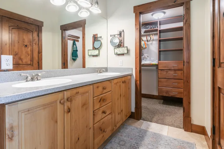 Double vanity with light-colored countertops and wood-finish cabinetry