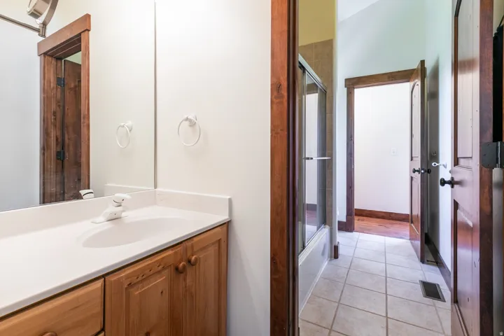 Bathroom vanity featuring a white countertop with an integrated sink, wood cabinetry, and a framed mirror