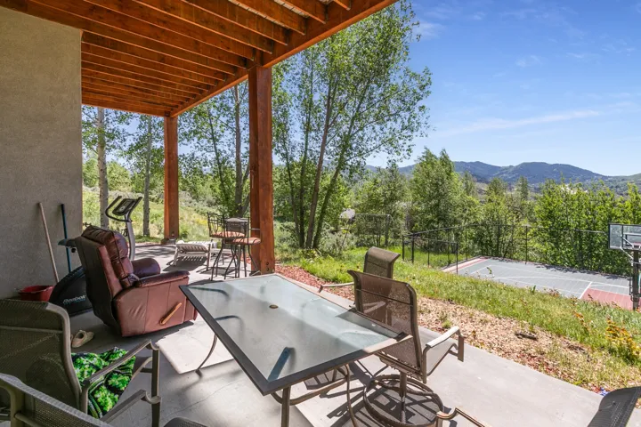 Expansive covered patio featuring a concrete surface and exposed wood beam ceiling