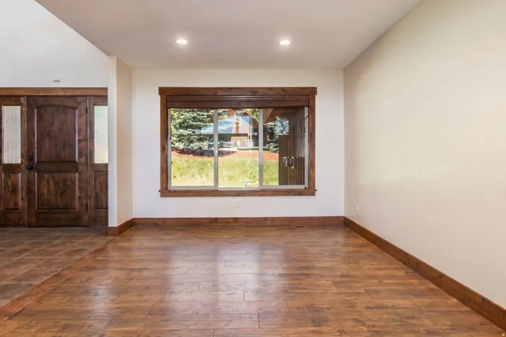 Spacious interior featuring wood-finish flooring, recessed lighting, and a large window with wood trim
