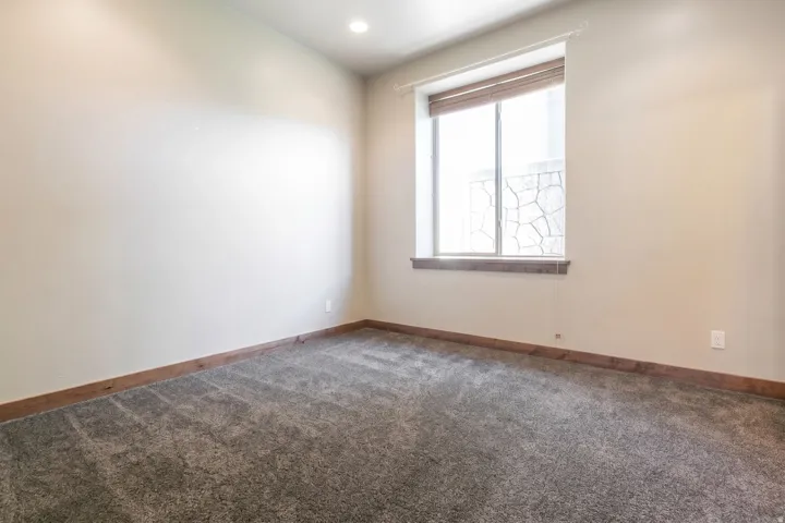 Neutral tone walls with recessed lighting, complemented by wood-finish baseboards and a coordinating window sill