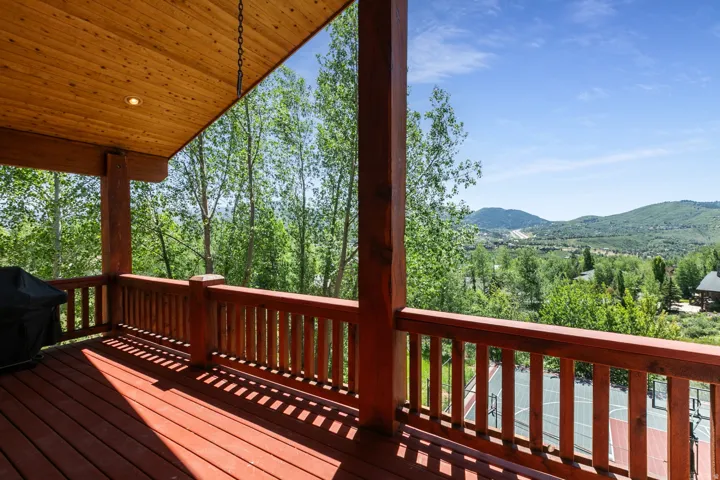 Expansive outdoor deck featuring wood-finish flooring and railing