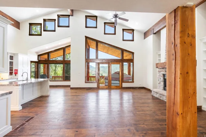 Vaulted ceilings featuring exposed timber beams and an array of windows