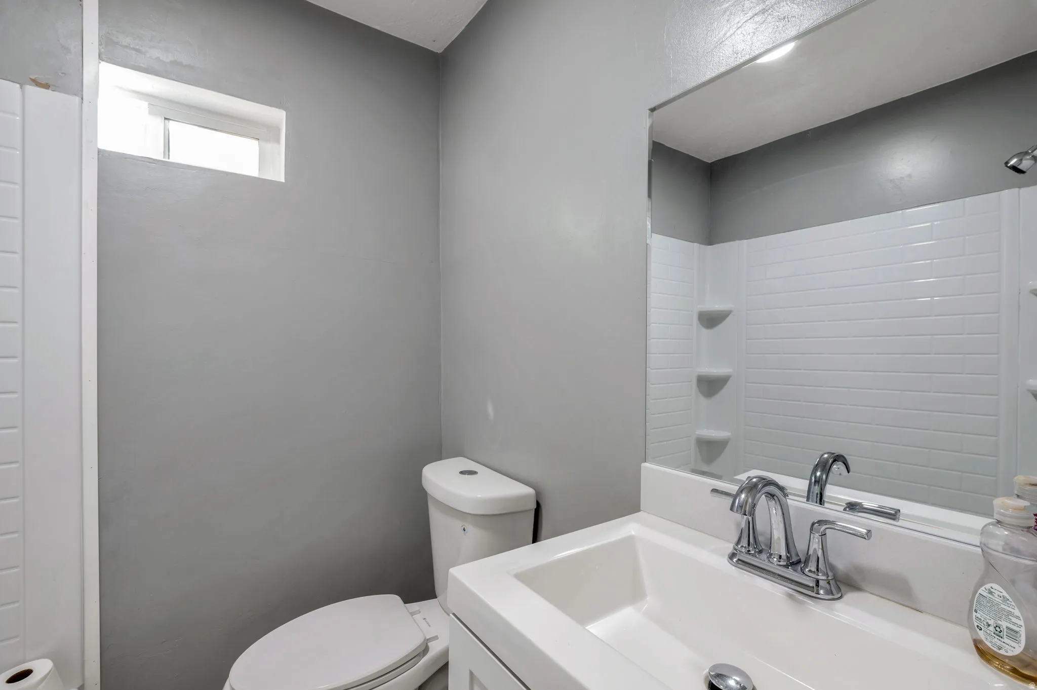 Bathroom featuring a white subway tile shower surround with integrated shelving